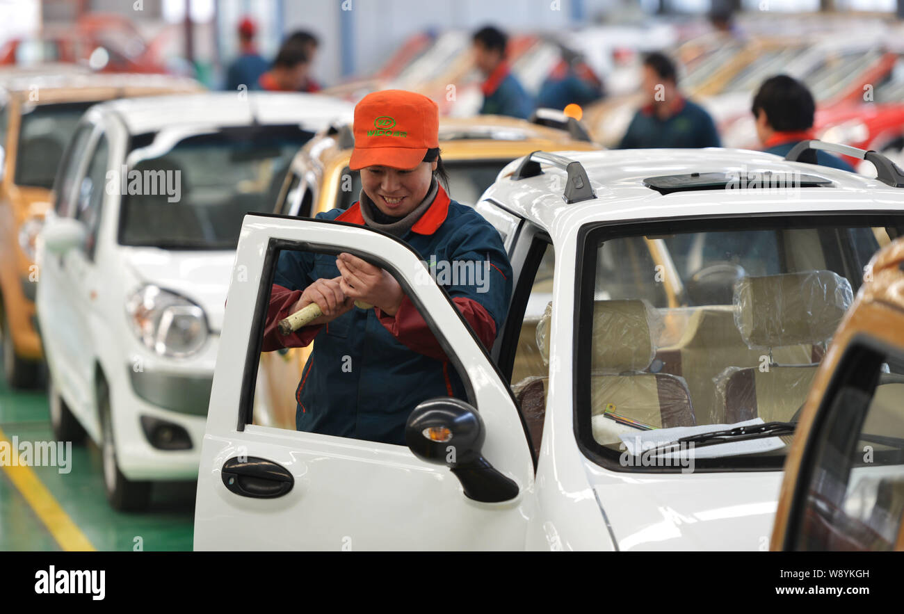 Chinese workers assemble electric cars on the assembly line at the auto ...