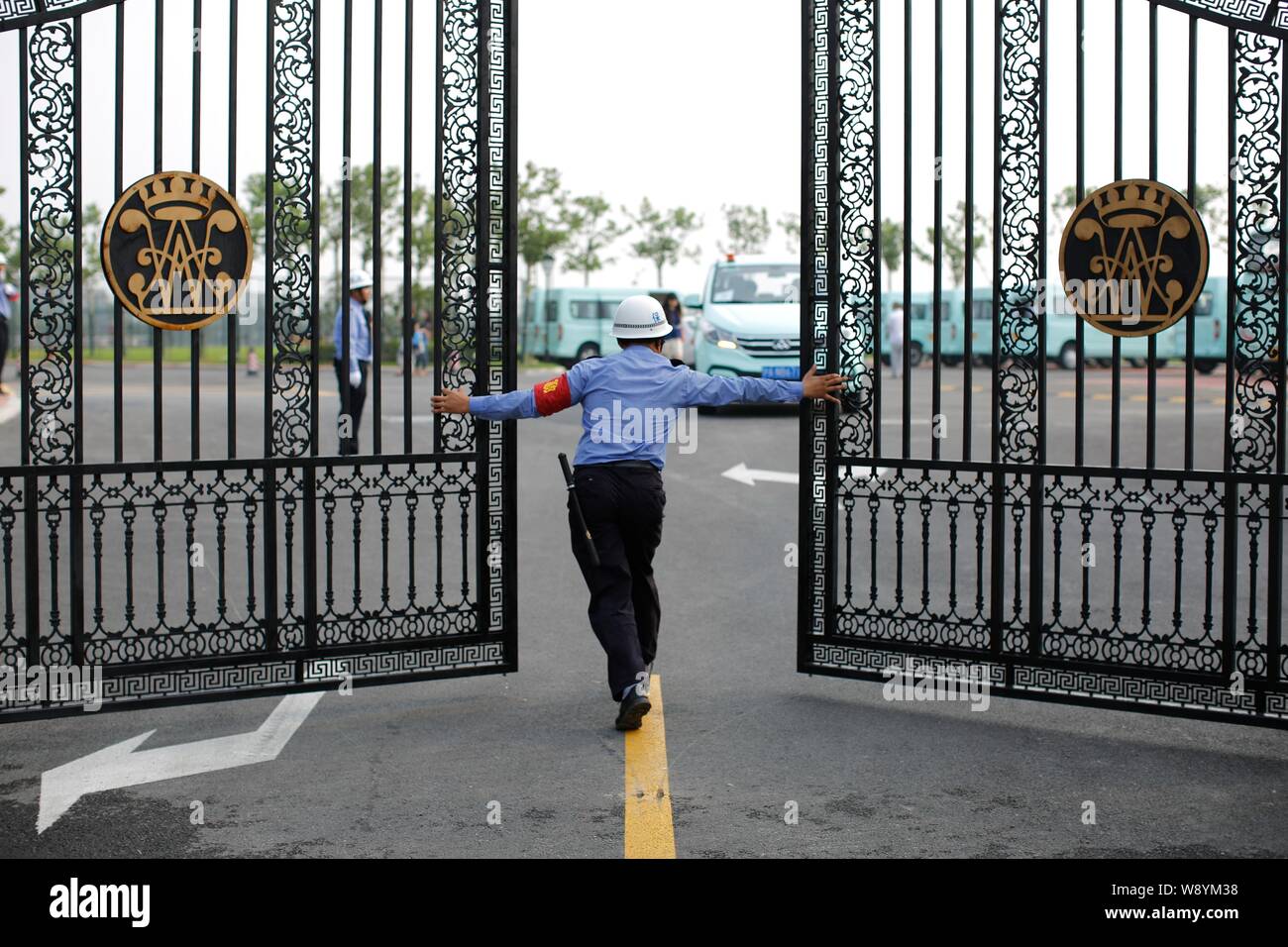 A security guard opens the gate of Wellington College International