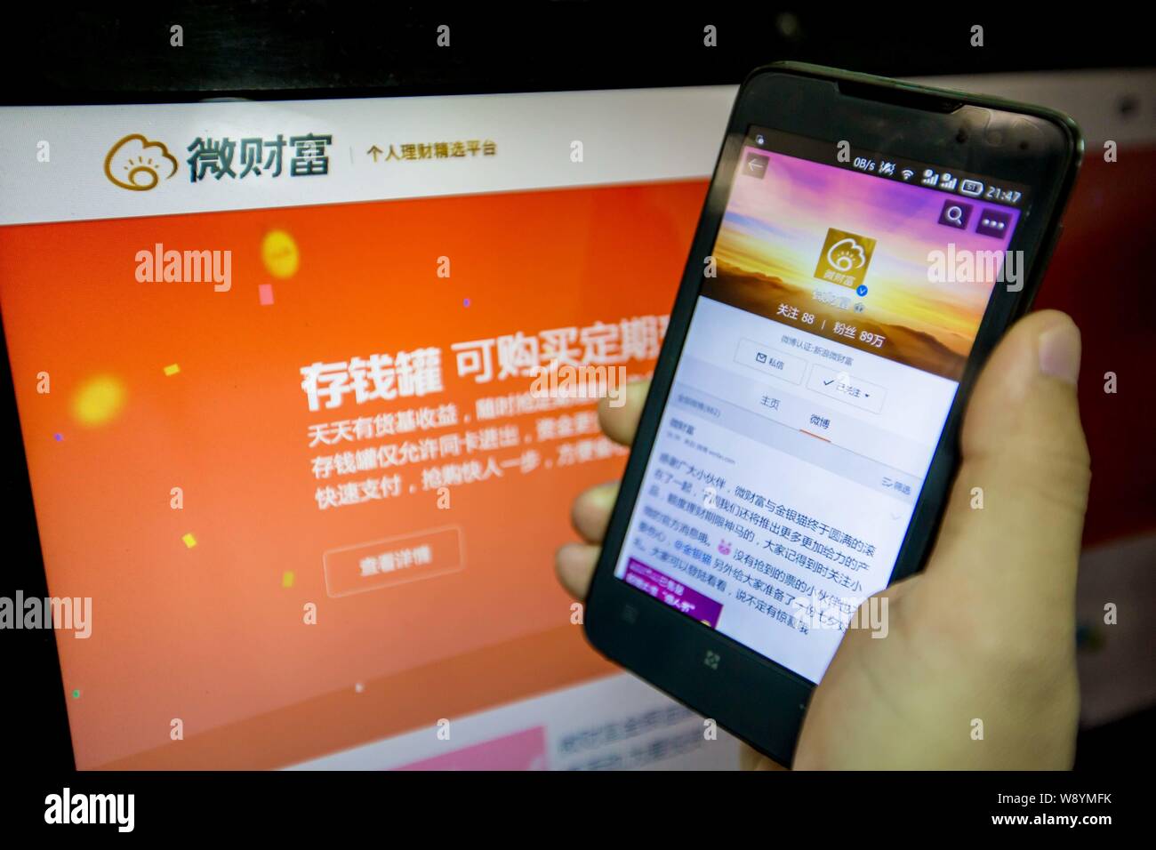 --FILE--A Chinese mobile phone user looks at information of Weicaifu, the wealth management service of Sina, in Guangzhou city, south China's Guangdon Stock Photo