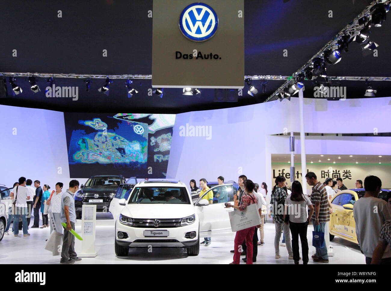 --FILE--Visitors look at a Volkswagen Tiguan SUV and other cars at the stand of Shanghai Volkswagen, a joint venture between SAIC and VW, during an au Stock Photo