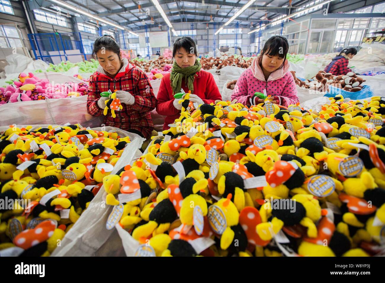 Female Chinese workers sew stuffed toys to be exported to Europe and the United States at a garment factory in Ganyu Economic Development Area in Lian Stock Photo