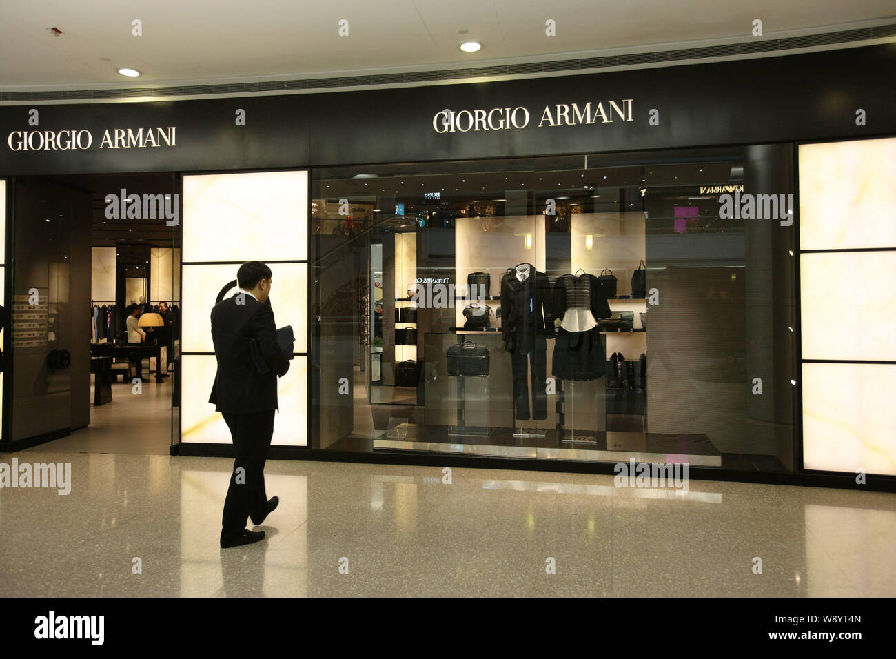 FILE--A customer walks towards the Giorgio Armani store at Plaza 66 in  Shanghai, China, 21 November 2012. Italian luxury goods brand Armani recent  Stock Photo - Alamy