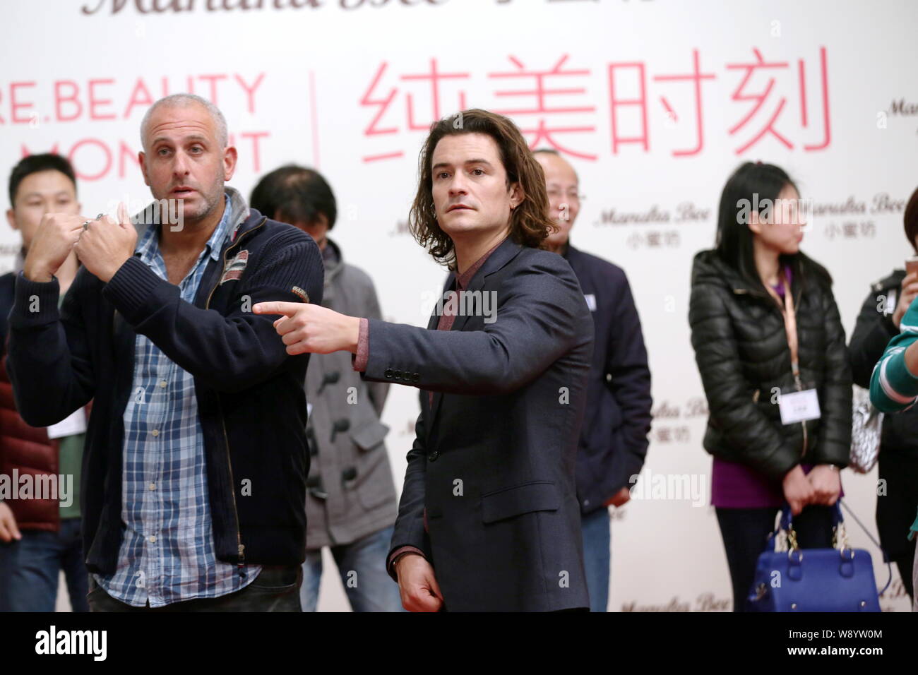 English actor Orlando Bloom, center, attends a promotional event for Manuka Bee Lip Care in Shanghai, China, 16 December 2014. Stock Photo