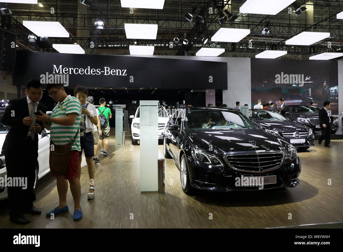 --FILE--Visitors stand next to a Mercedes-Benz E-Class during an automobile exhibition in Fuzhou city, southwest Chinas Fujian province, 30 September Stock Photo
