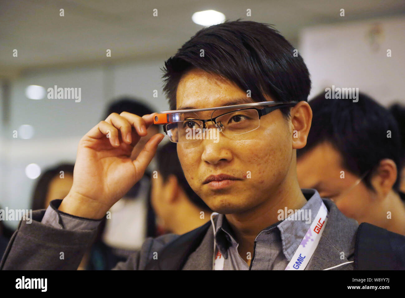 A visitor tries out Google Glass during the 2014 Global Mobile Internet Conference (GMIC 2014) in Beijing, China, 5 May 2014.   Google Glass and Apple Stock Photo