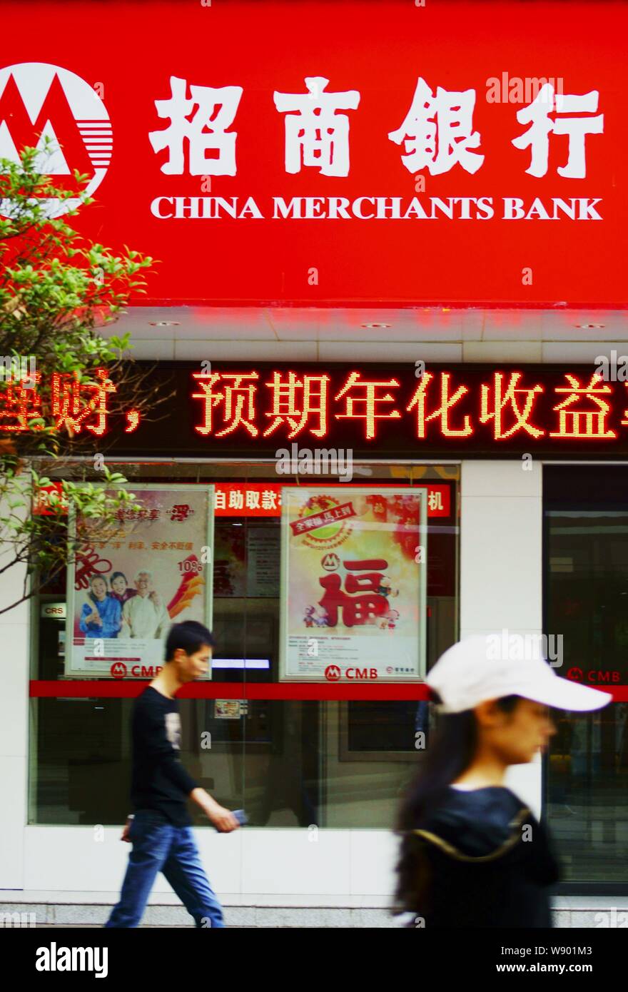 --FILE--Pedestrians walk past a branch of China Merchants Bank (CMB) in Yichang city, central Chinas Hubei province, 12 May 2014.   Several midsize ba Stock Photo