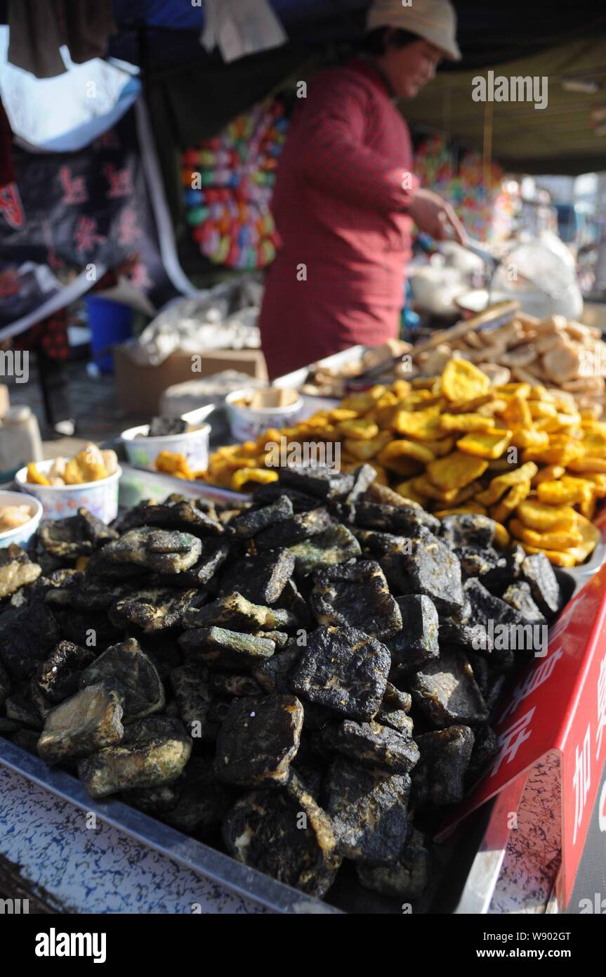 --FILE--A vendor fries fermented tofu (stinky tofu) at a stall during a food fair in Binzhou city, east Chinas Shandong province, 22 February 2013. Stock Photo