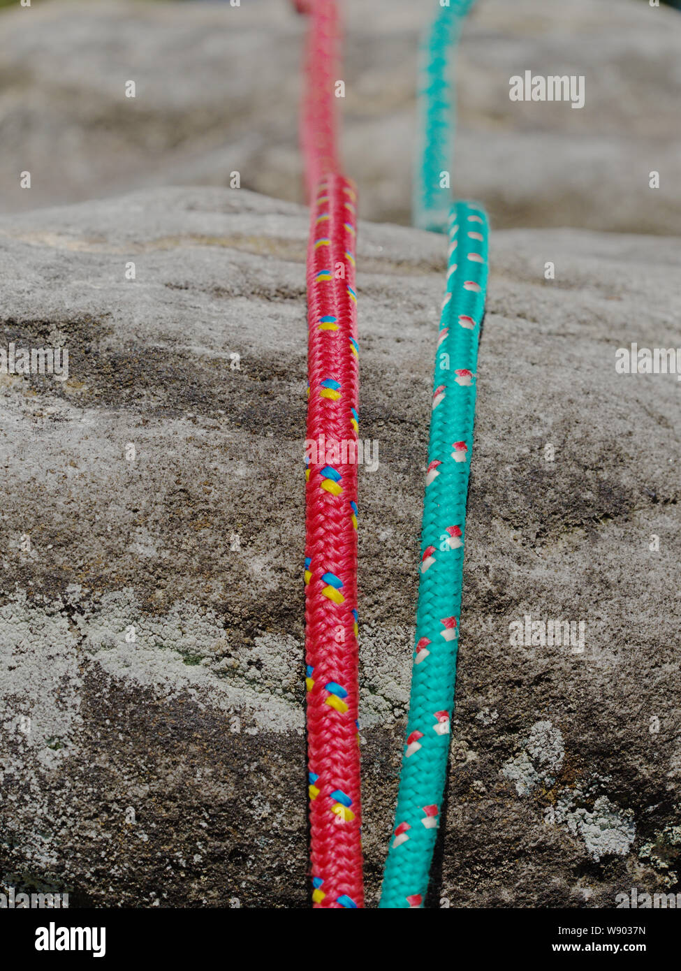 Nylon rope on gray rocky background. Climbing equipment. Twisted old ...