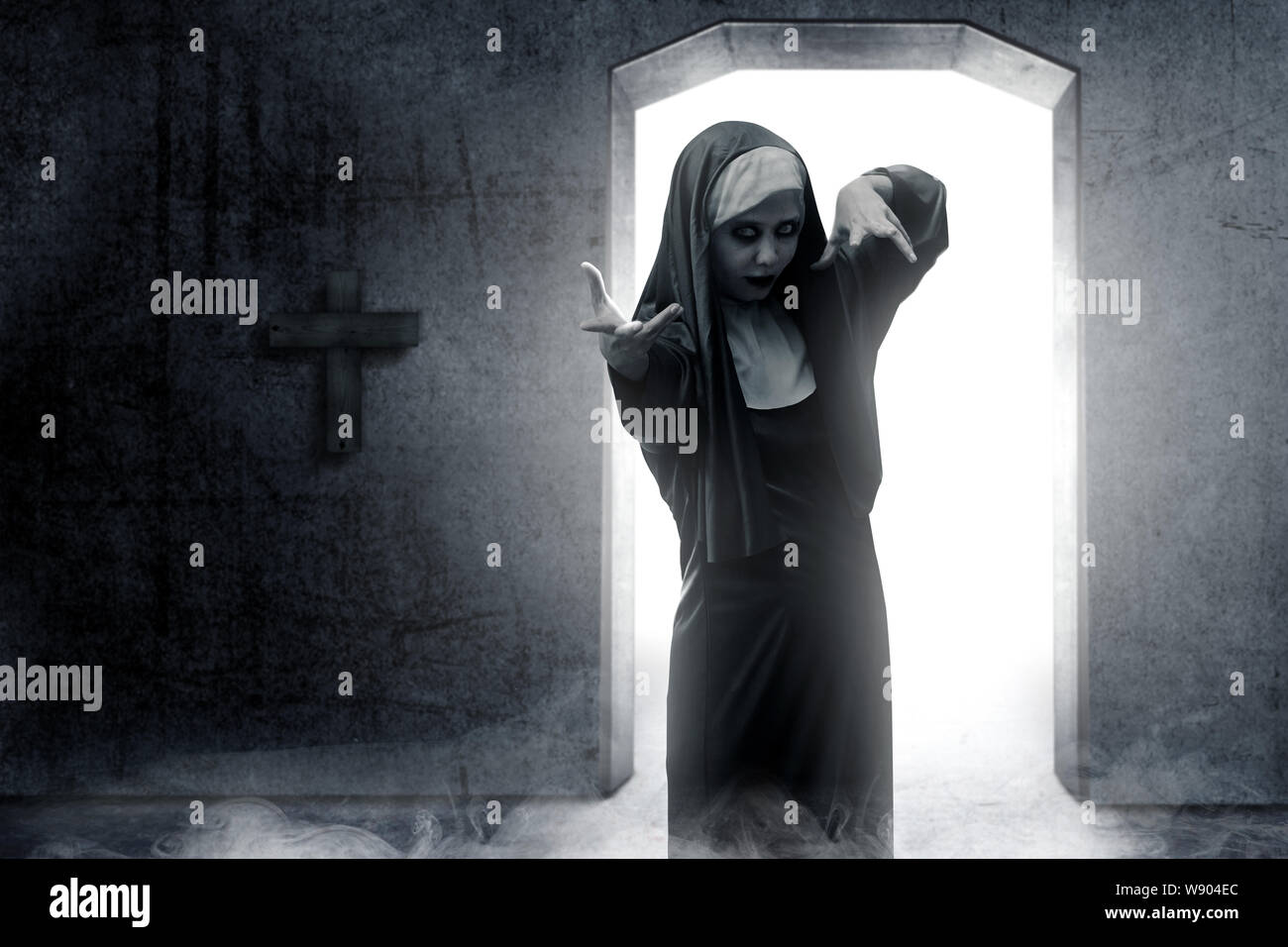 Frightening devil nun haunted the darkroom. Halloween concept Stock Photo