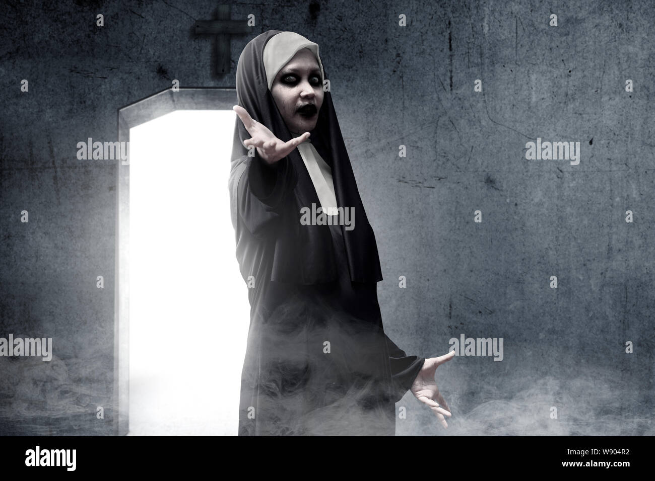 Frightening devil nun haunted the darkroom. Halloween concept Stock Photo