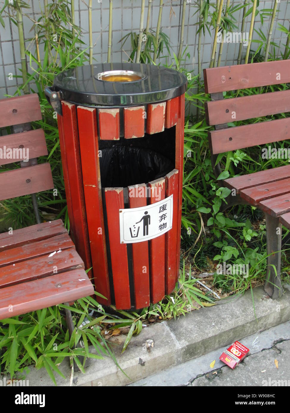 An Empty Cigarette Box Is Discarded In Front Of A Garbage Bin