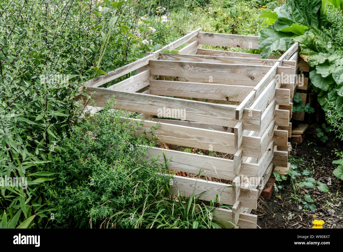 Wooden composter located in the shady part of the garden, Stock Photo