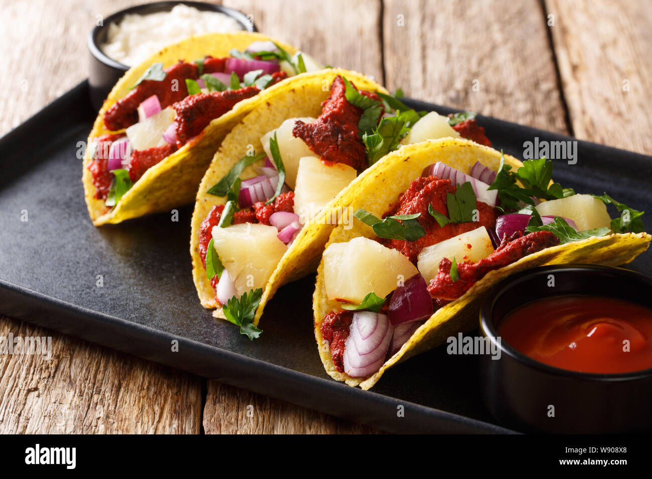 Mexican tacos al pastor served with sauce closeup on a plate on the table. horizontal Stock Photo