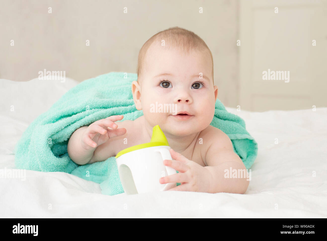 https://c8.alamy.com/comp/W90ADX/baby-girl-boy-wrapped-in-a-towel-holding-a-non-spill-cup-cute-cheerful-caucasian-baby-with-brown-eyes-portrait-soft-focus-W90ADX.jpg