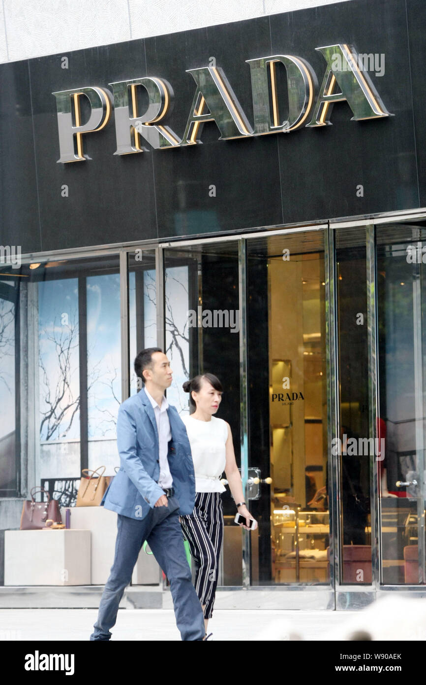 FILE--Pedestrians walk past a Prada boutique in Shanghai, China, 22  September 2014. On Sept 30 Prada announced that the company chairperson  Miucci Stock Photo - Alamy