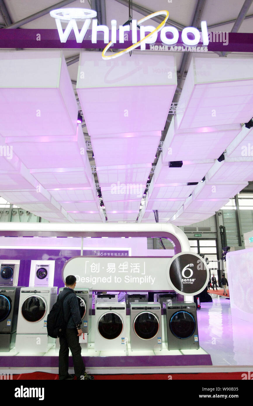 --FILE--A visitor looks at Whirlpool washing machines during an exhibition in Shanghai, China, 23 March 2014.     Whirlpool Corp., hurt by falling sal Stock Photo