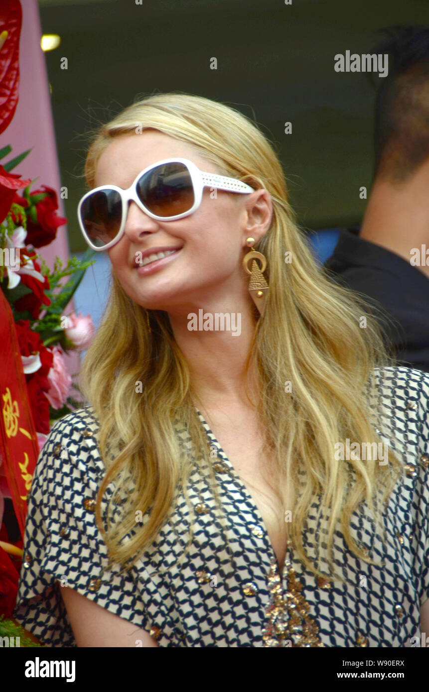 American socialite Paris Hilton smiles as she arrives at the opening