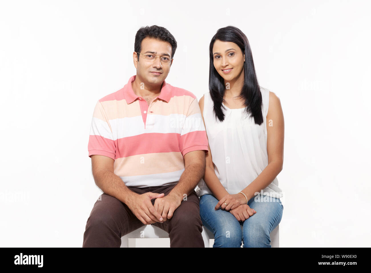 Couple sitting on stool Stock Photo
