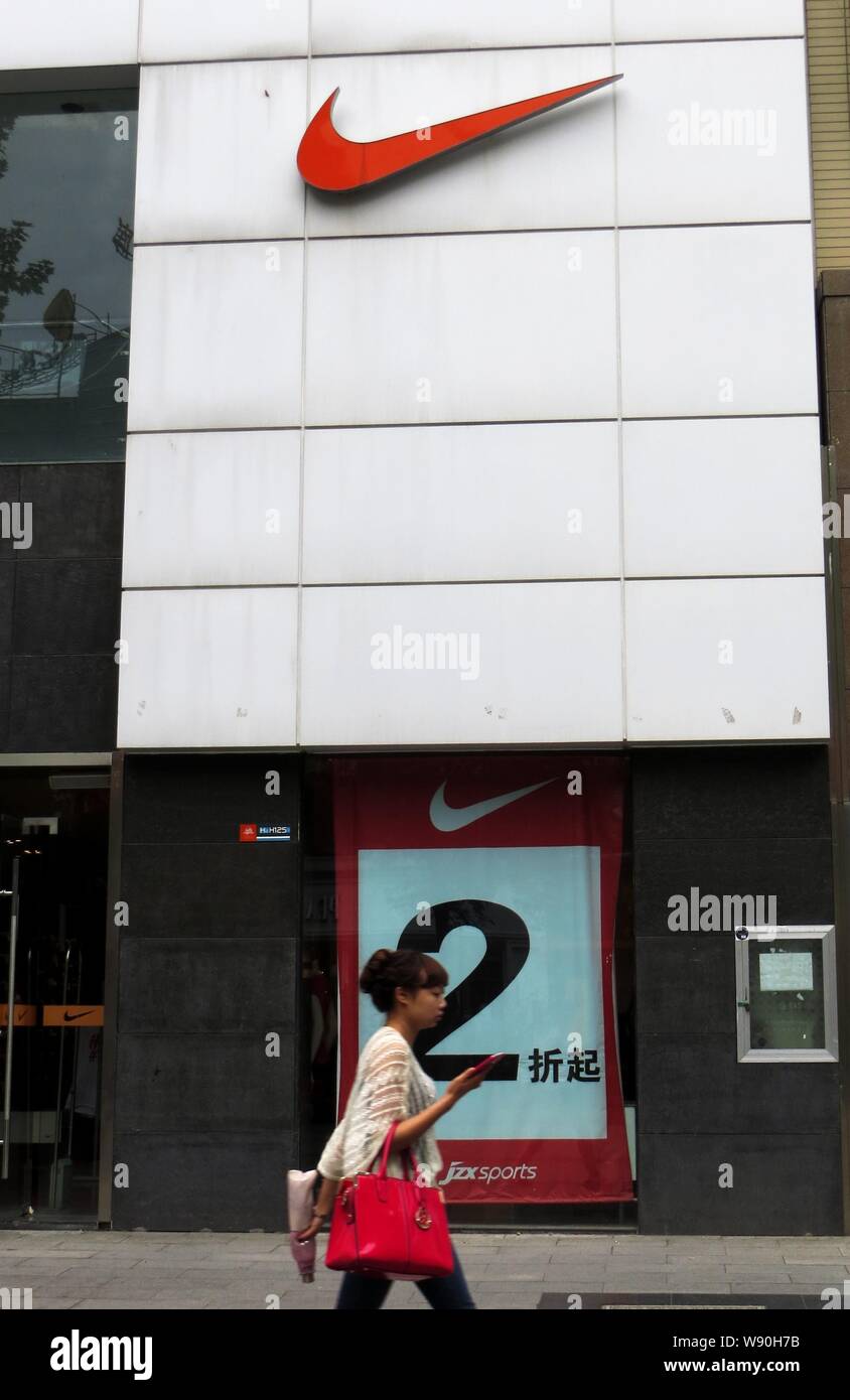 --FILE--A pedestrian walks past a sportswear store of Nike in Yichang city, central Chinas Hubei province, 2 May 2013.       Nike Chief Executive Mark Stock Photo