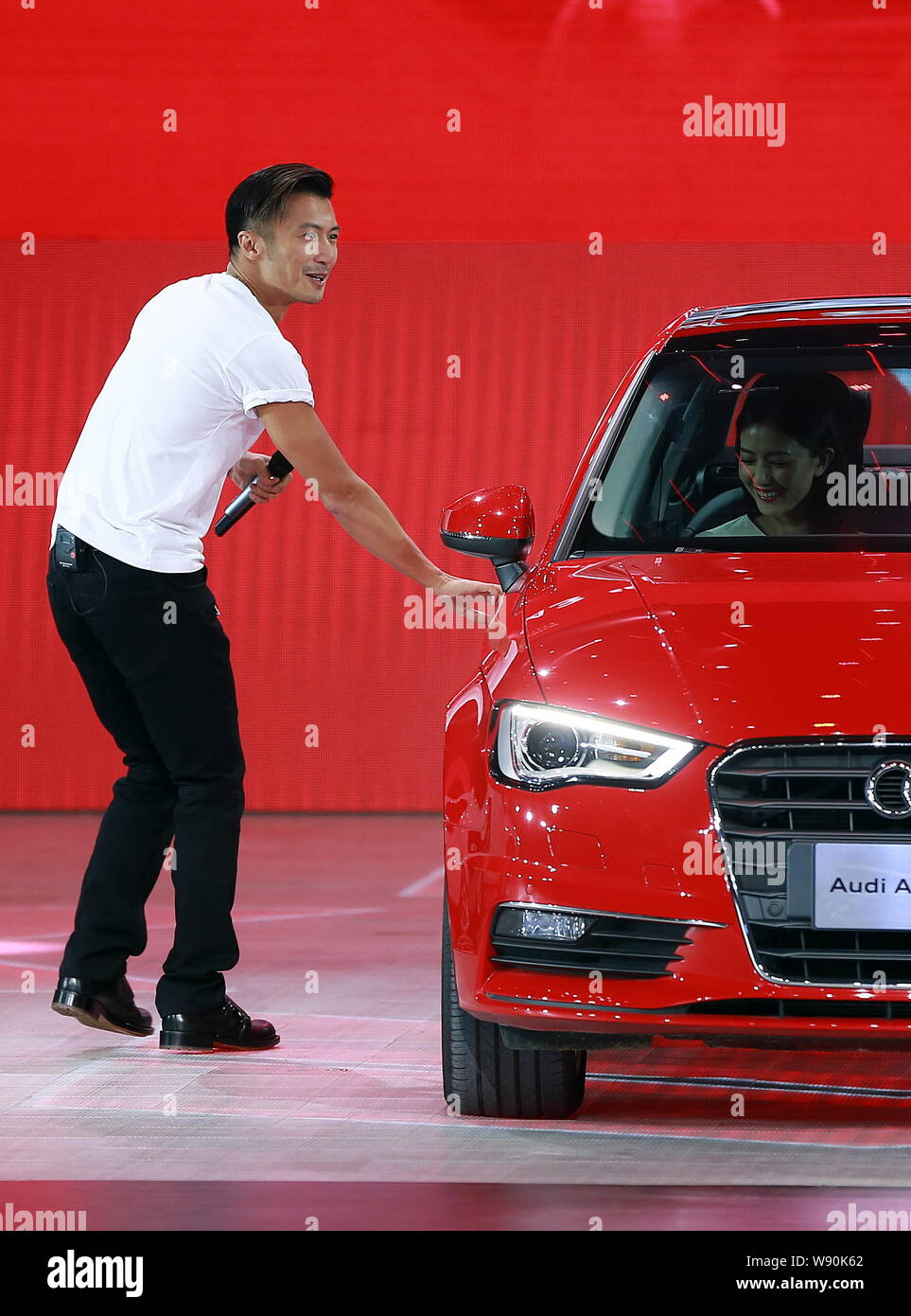 Hong Kong singer and actor Nicholas Tse, left, opens the door for ...