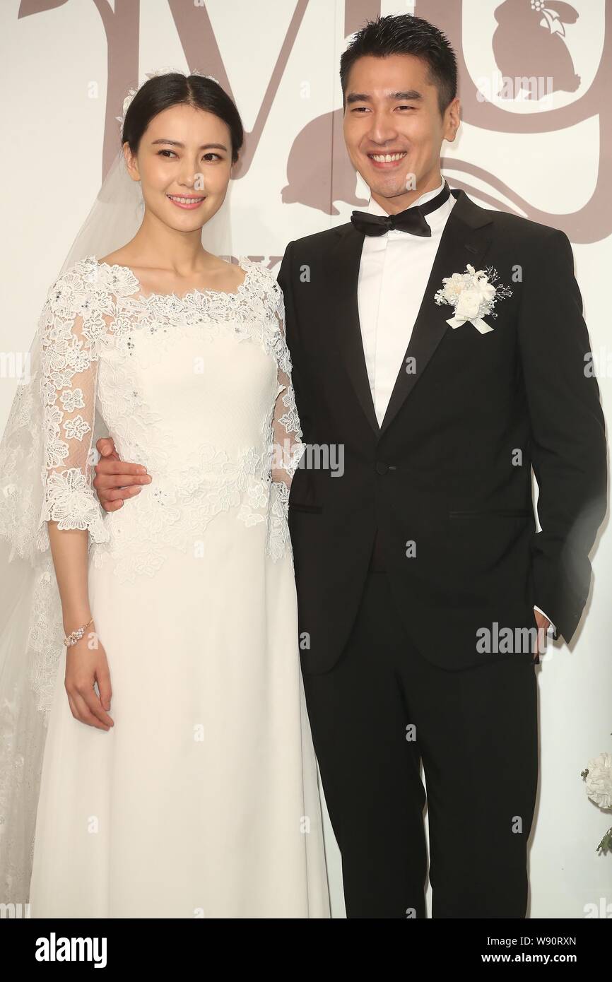 Chinese actress Gao Yuanyuan, left, and her Taiwanese actor husband Mark Chao pose during their wedding banquet in Taipei, Taiwan, 28 November 2014. Stock Photo