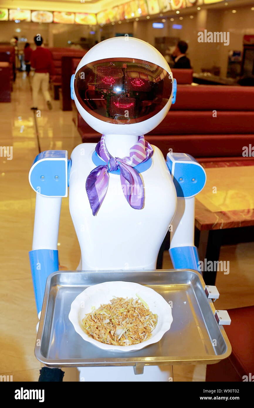 A robot waiter delivers food at a restaurant in Cixi city, east China's Zhejiang province, 27 November 2014.   A Chinese restaurant fascinates the pub Stock Photo