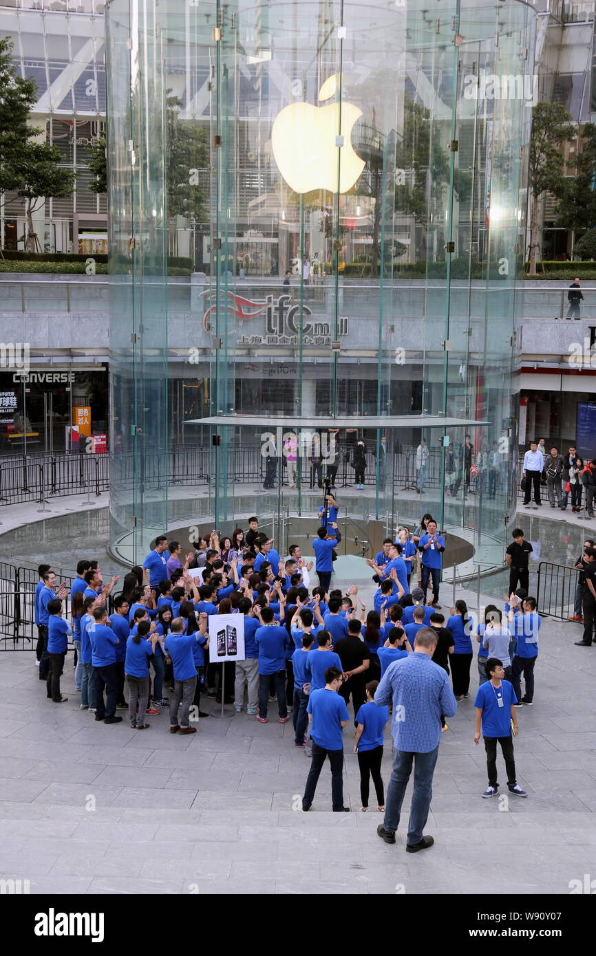 Employees applaud and congratulate customers who bought iPhone 6 and iPhone 6 Plus smartphones outside the Apple Store in the Lujiazui Financial Distr Stock Photo