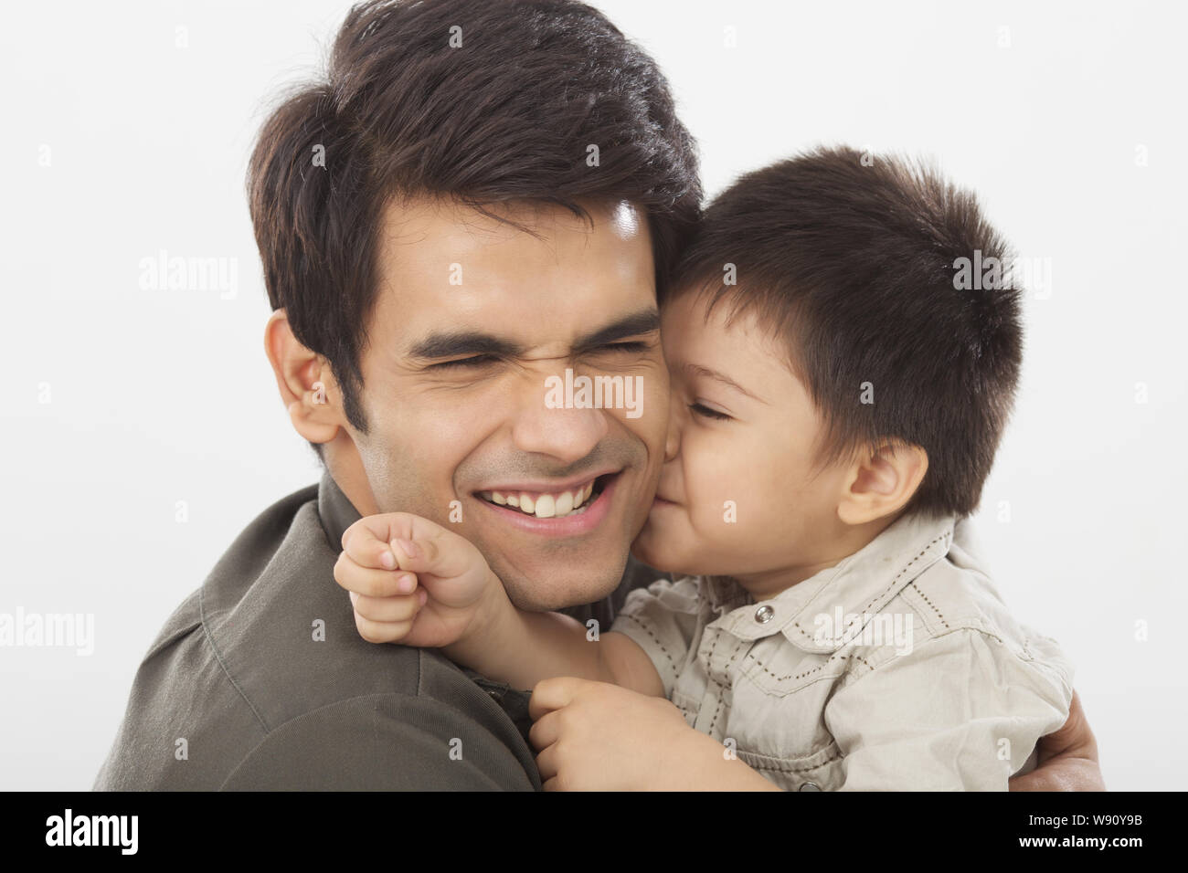 Boy kissing his father's cheek Stock Photo