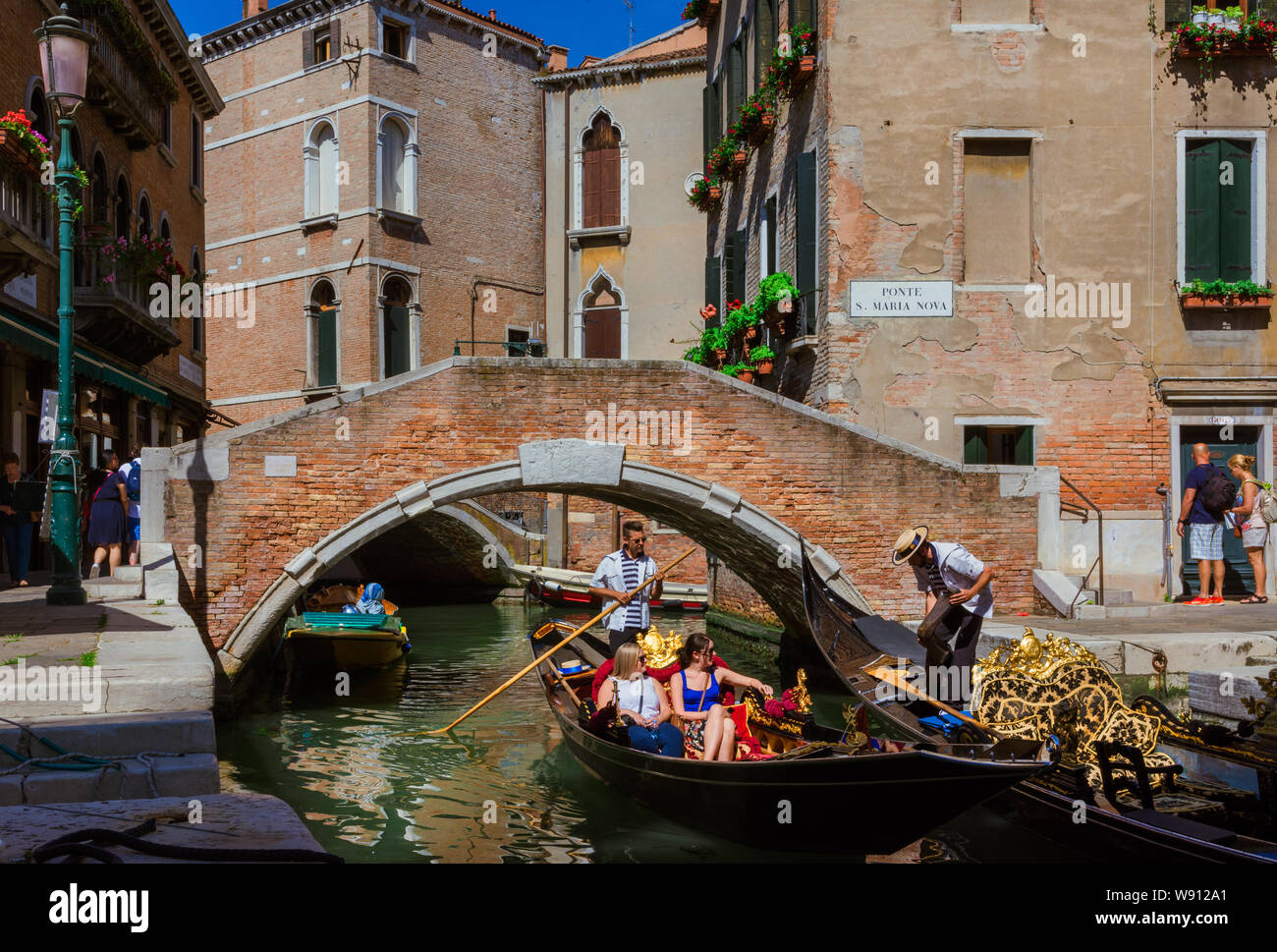 Sightseeing in Venice. Tourists take a private gondola tour in the city historical center Stock Photo