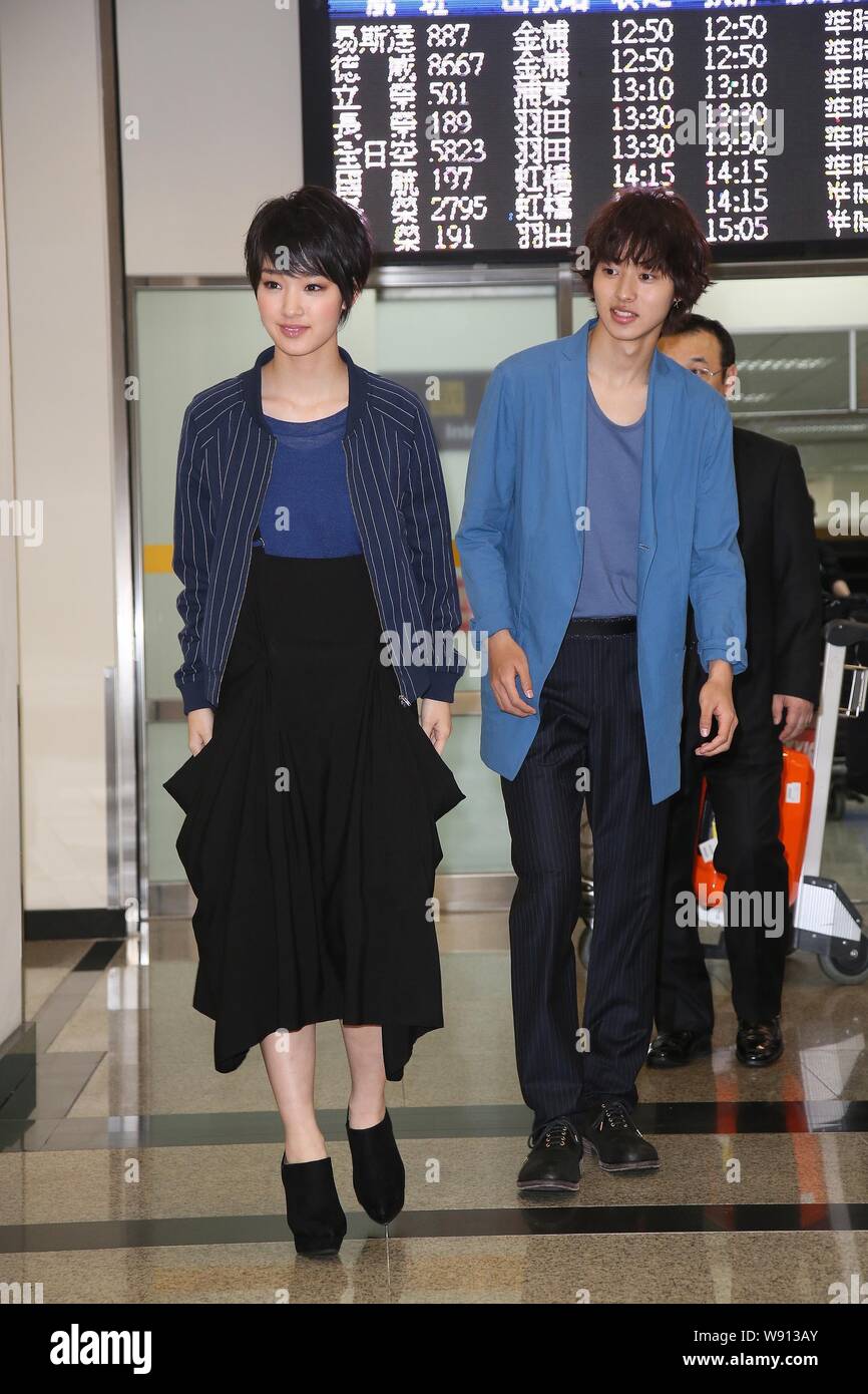 Japanese actress Ayame Goriki, left, and actor Kento Yamazaki walk towards the exit at the Taiwan Taoyuan International Airport after arriving in Taip Stock Photo