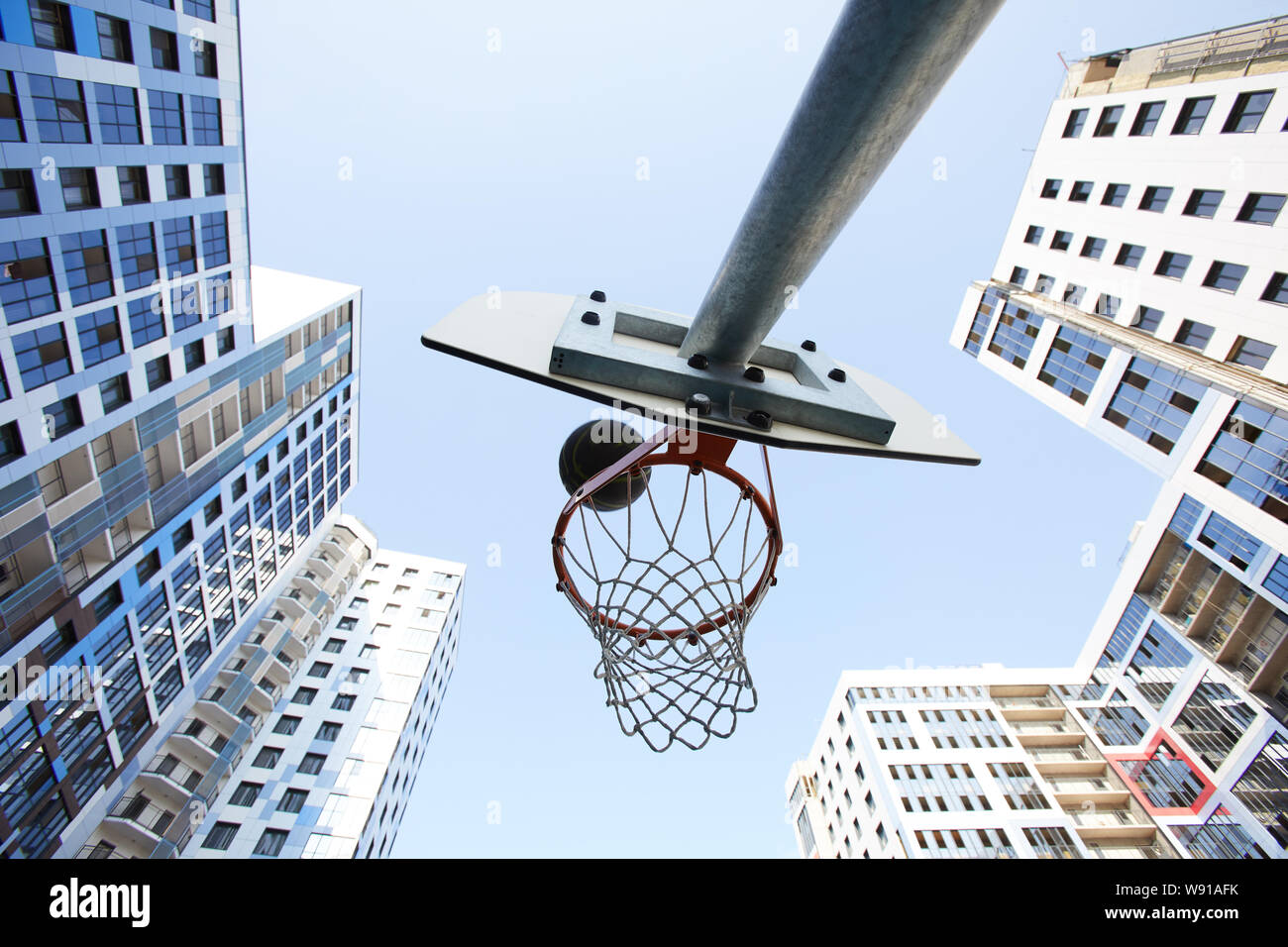 Low angle view at basketball hoop in urban background, copy space Stock Photo