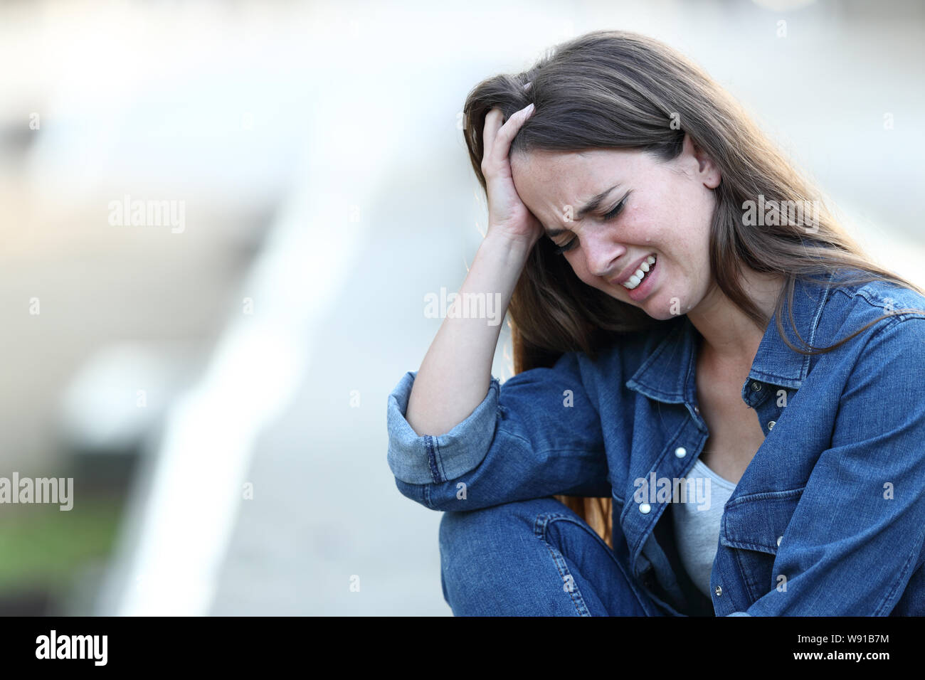 Sad woman crying and complaining in the street Stock Photo