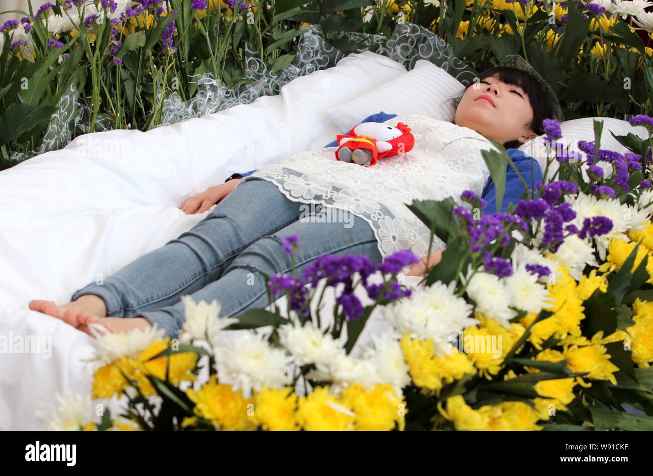 Zeng Jia, a 20-year-old college student takes part in a faux funeral in Wuhan city, central Chinas Hubei province, 30 March, 2013.   A pallbearer adju Stock Photo