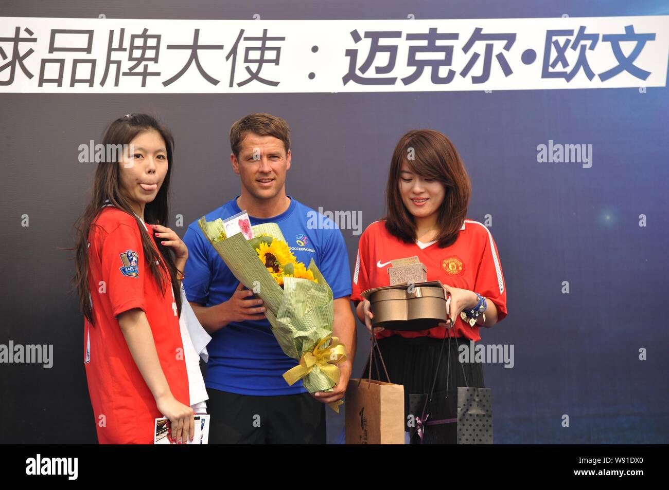 English soccer star Michael Owen, center, poses with female fans at a promotional event of European sports stadium business operator SoccerWorld durin Stock Photo