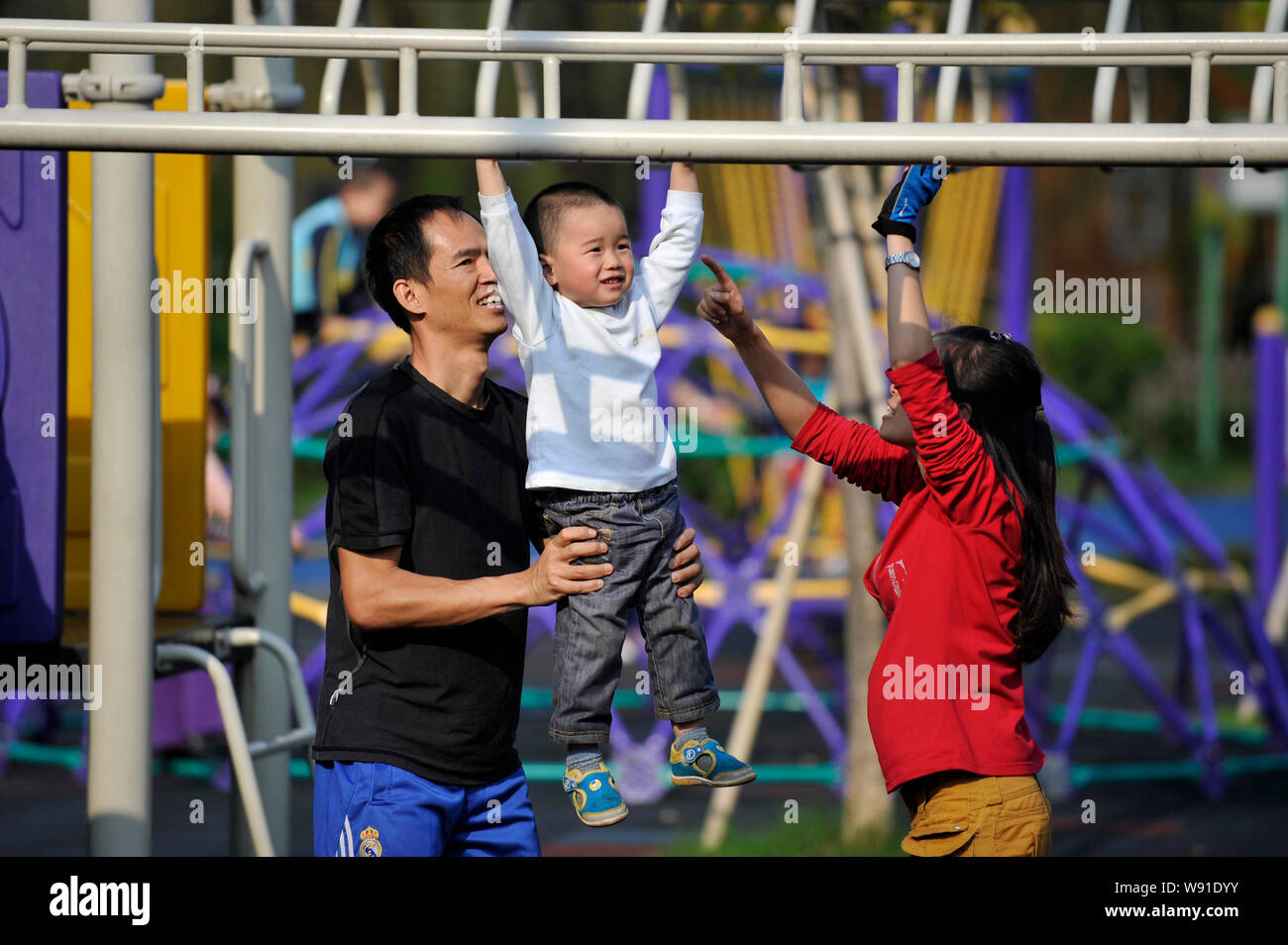 --FILE--A Chinese couple and their only son play at a park in Guangzhou city, south Chinas Guangdong province, 12 April 2013.   China formally approve Stock Photo