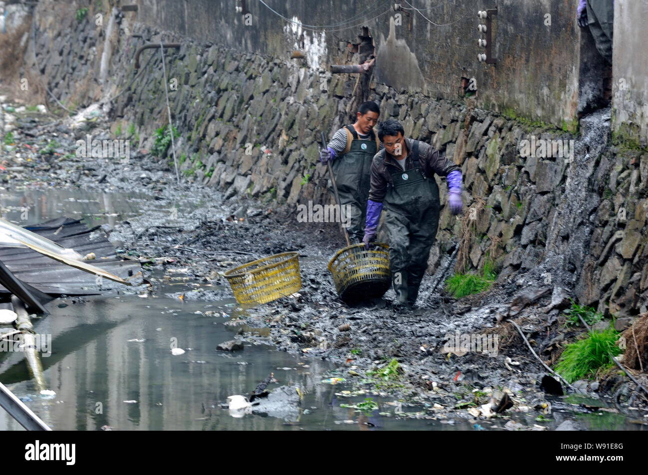 --FILE--Sanitation workers clean up a polluted river in Ruian city, southeast Chinas Zhejiang province, 18 February 2013.   Web journalist/activist De Stock Photo