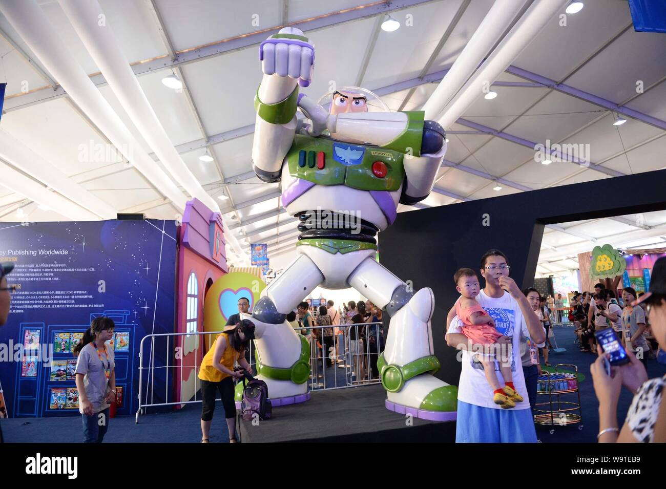 --FILE--Visitors take photos with a figure of Buzz Lightyear, a character in Toy Story produced by Disney, at the stand of Toy Story during an anime s Stock Photo