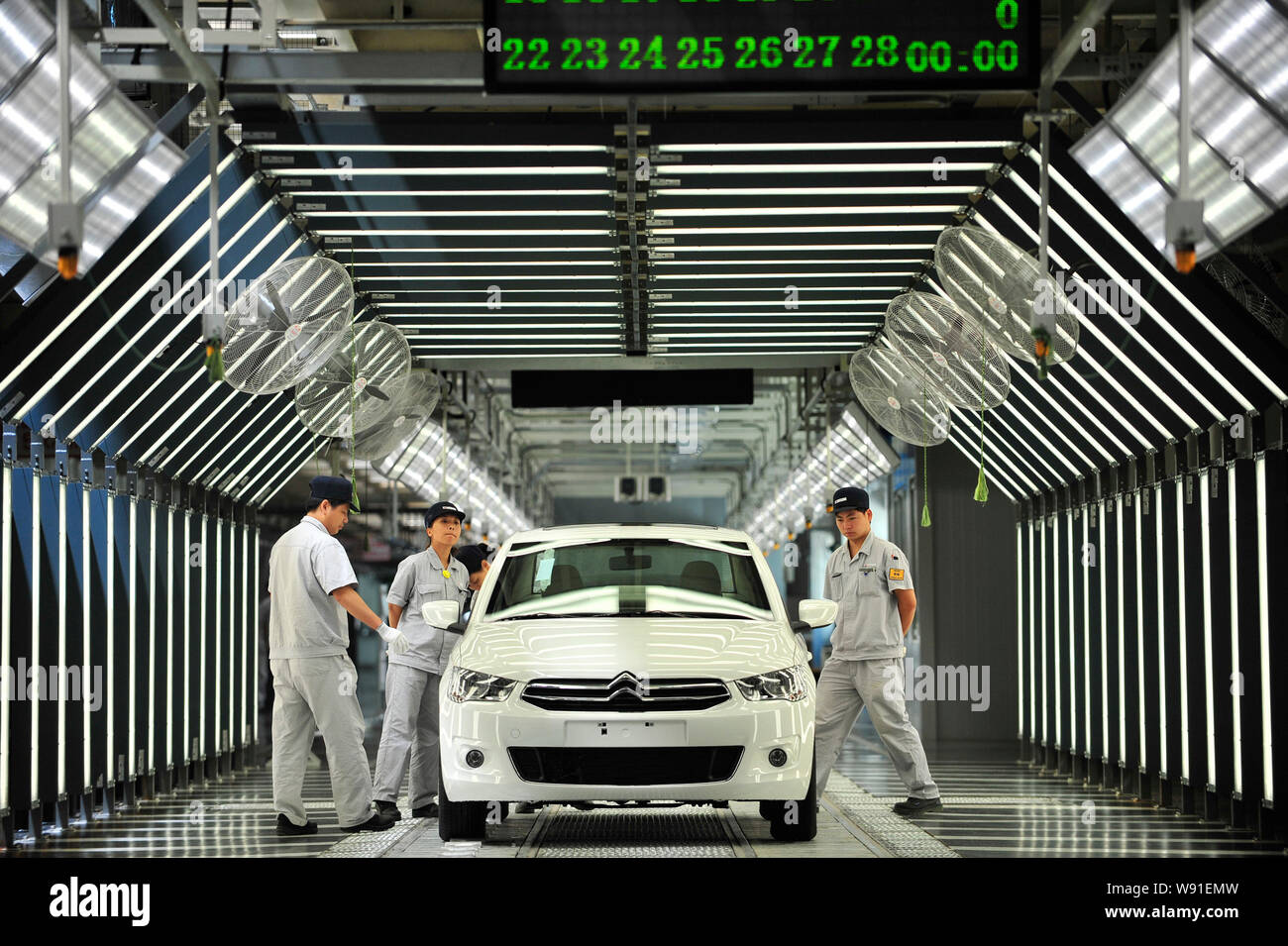 Chinese workers examine a Citroen Elysee on the assembly line at the ...