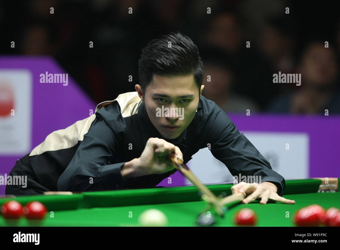 Cao Yupeng of China plays a shot against Ding Junhui of China in their  first round match of the 2013 World Snooker International Championship in  Cheng Stock Photo - Alamy