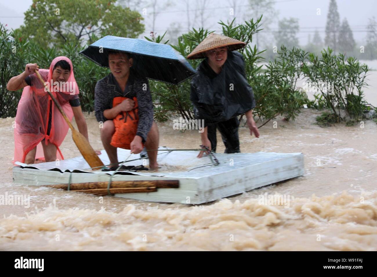 Local Chinese residents row a raft on a street in the rainstorm caused by typhoon Fitow in Taoshan town, Ruian city, east Chinas Zhejiang province, 7 Stock Photo
