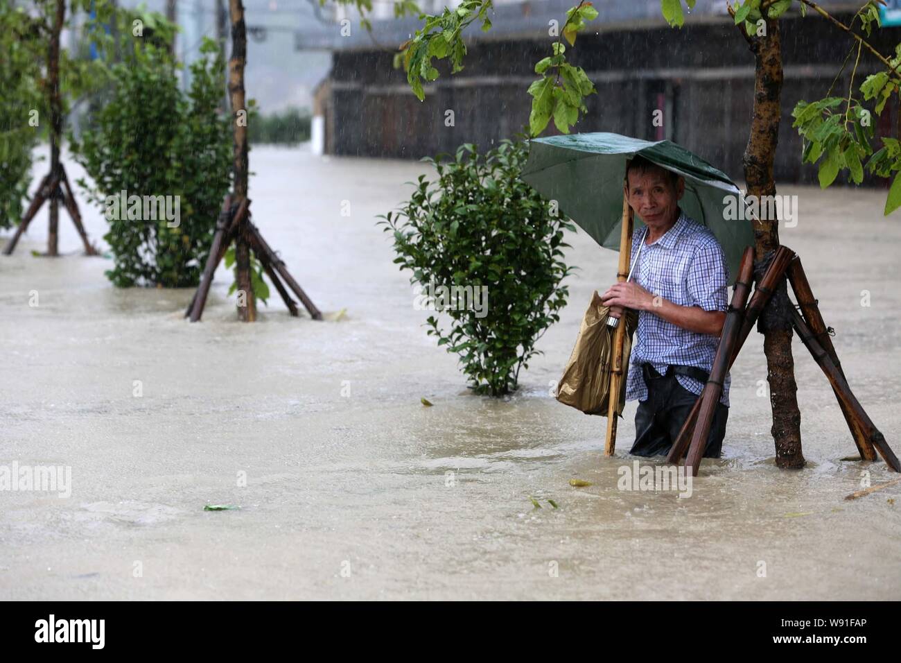 A local Chinese resident stands on a flooded street in the rainstorm caused by typhoon Fitow in Taoshan town, Ruian city, east Chinas Zhejiang provinc Stock Photo