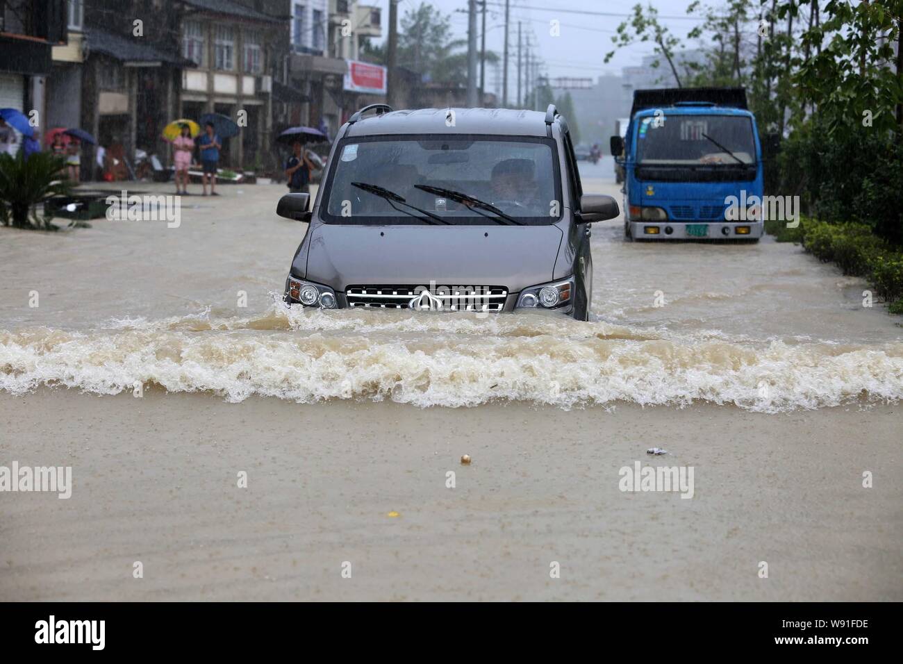 Cars travel on a flooded street after heavy rain caused by typhoon Fitow in Taoshan town, Ruian city, east Chinas Zhejiang province, 7 October 2013. Stock Photo