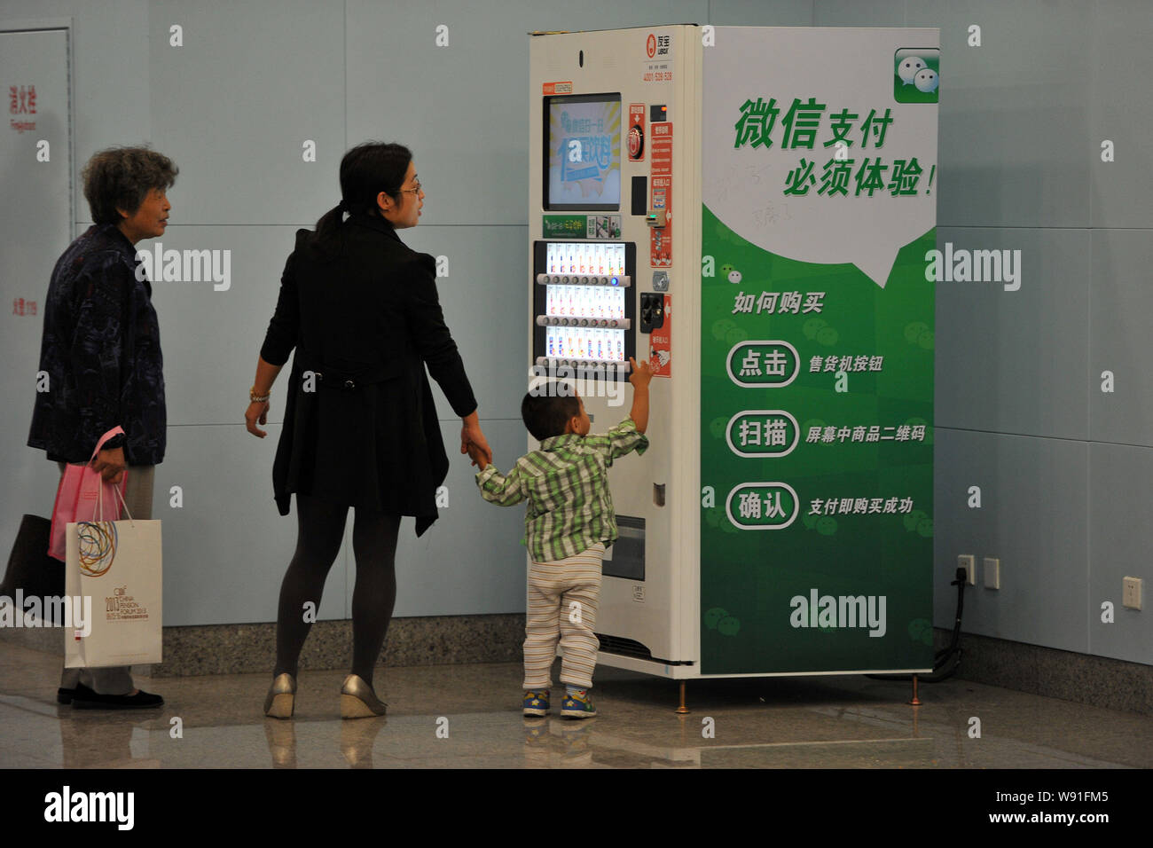 Chinese customers buy bottled drinks on a vending machine within the Wechat app in a subway station in Beijing, China, 26 September 2013.   WeChat use Stock Photo
