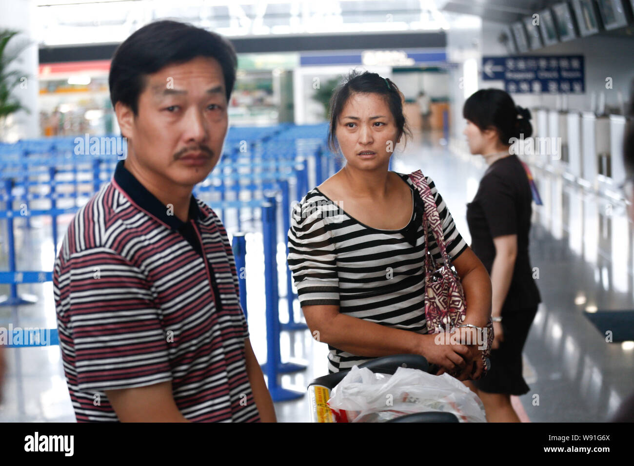 The parents of Chinese schoolgirl Wang Linjia, who died in the Asiana Airlines plane crash at San Francisco International Airport, queue up to get boa Stock Photo