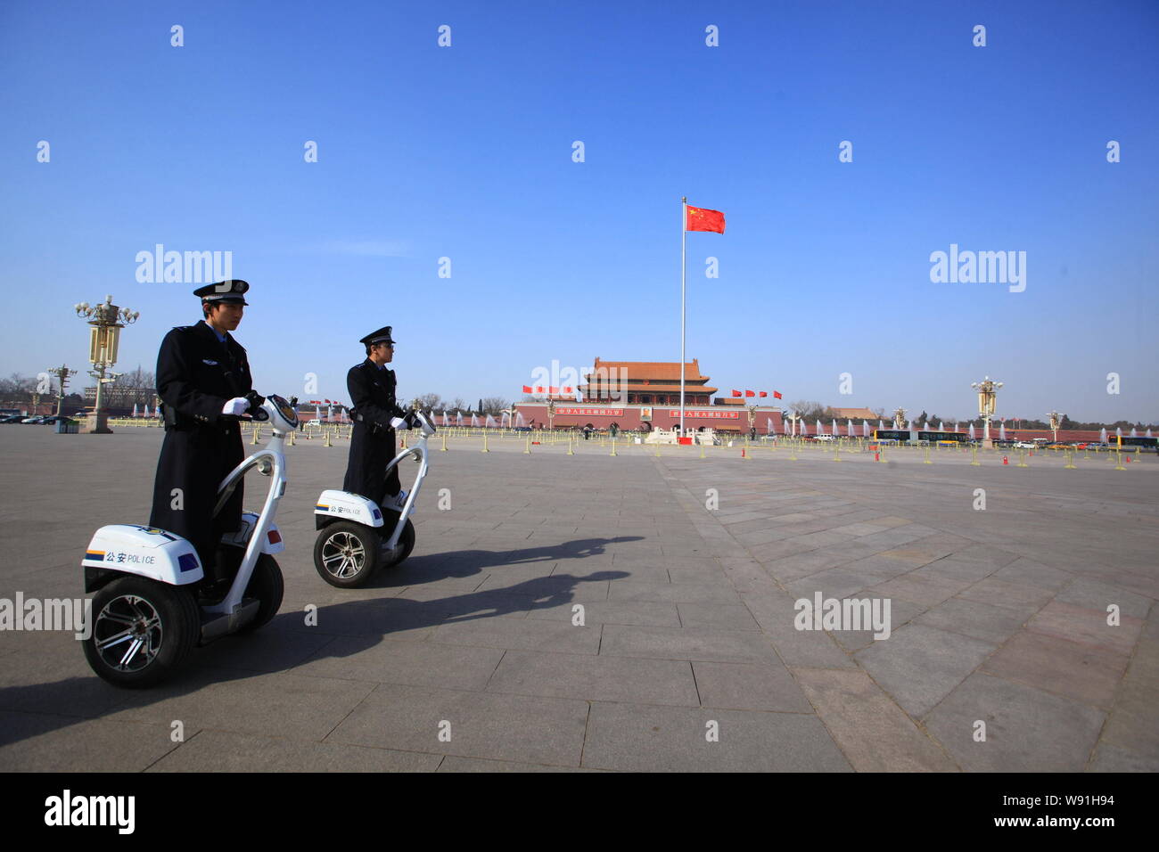 Chinese police officers drive Segway-like two-wheeled electric vehicle to patrol Tiananmen Square during the First Session of the 12th National Commit Stock Photo