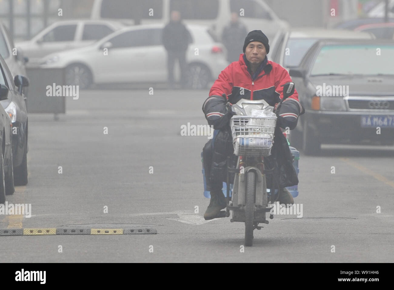 --FILE--A purified water deliveryman rides on a road in heavy smog in Beijing, China, 29 January 2013.   A new study links heavy air pollution from co Stock Photo