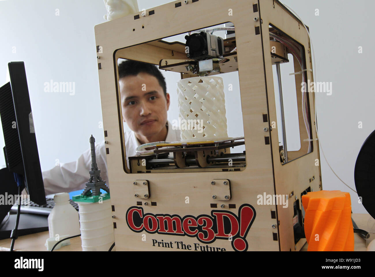 FILE--A Chinese man operates a 3D printer to make a pencil vase during a  demonstration at Wenzhou University in Wenzhou city, east Chinas Zhejiang p  Stock Photo - Alamy