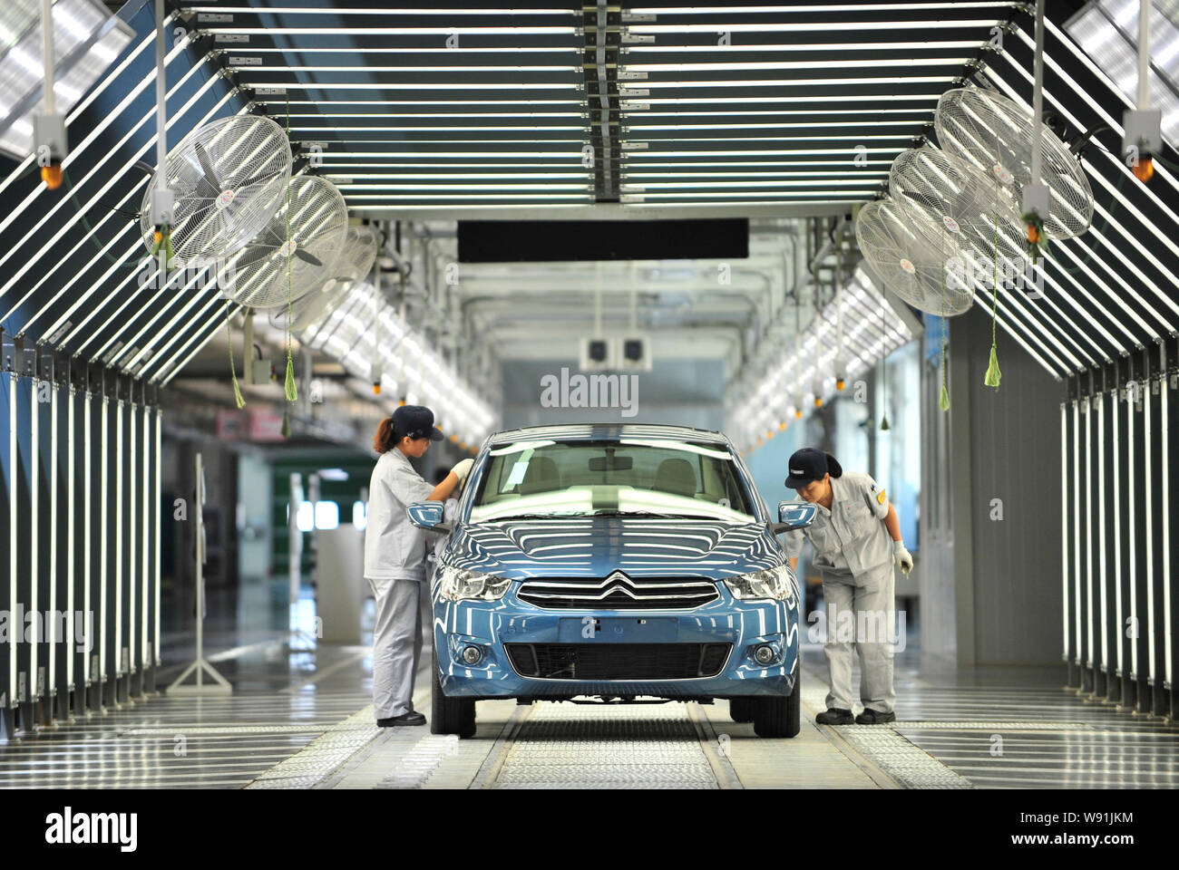 Chinese workers examine a Citroen Elysee on the assembly line at the ...