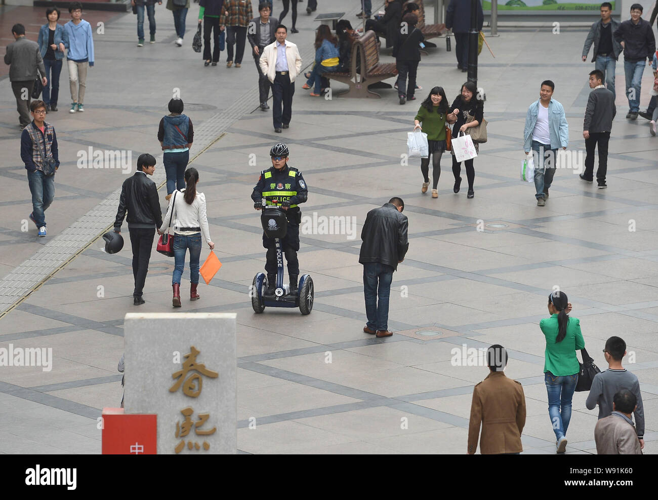 A Chinese police officer rides a Segway-like two-wheeled electric vehicle to patrol the Chunxi Road shopping street in Chengdu city, southwest Chinas Stock Photo