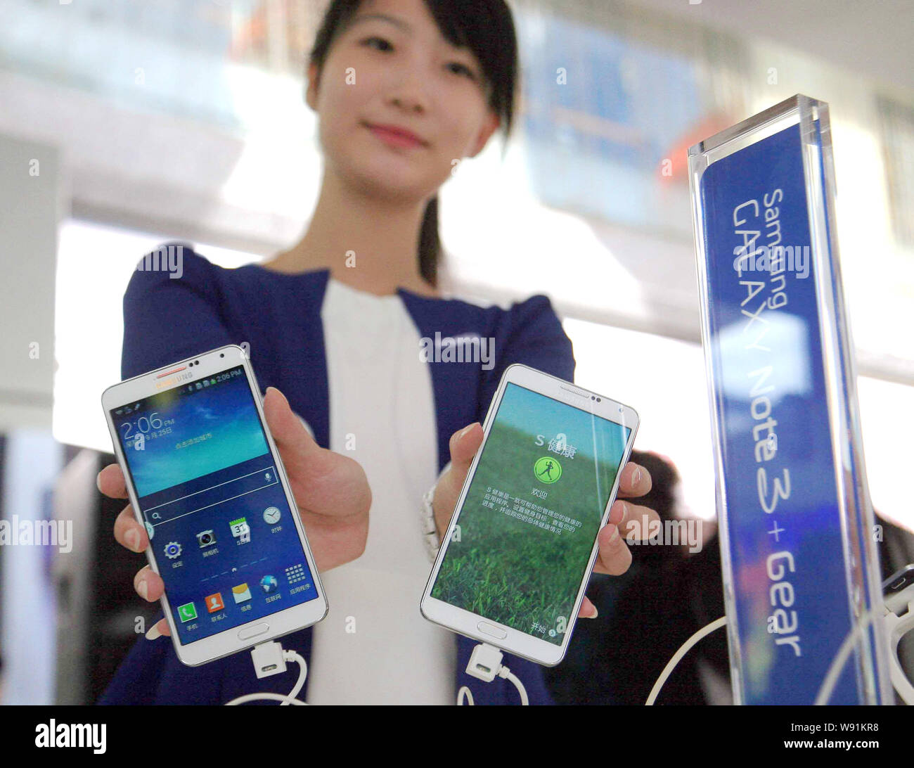 A Chinese employee shows the new Samsung Galaxy Note 3 smartphones at a